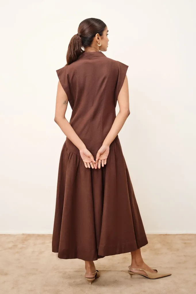 Brown dress in rayon flex featuring a lapel collar, cap sleeves, gold button detailing, straight calf-length silhouette, and matching belt..webp